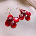 Close-up of elegant red enamel teardrop earrings with vintage gold-plated hooks. - Hook Style / Red