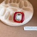 Close-up of a vintage red resin ring with a large crystal and pleated texture details. - Red and Transparent