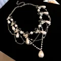 Elegant silver-tone butterfly necklace featuring teardrop pearls and sparkling rhinestones - Silver