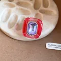 Close-up of vintage resin ring with large purple crystal and pleated red frame. - Pink and Light Purple