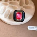 Macro detail view of a vintage court-style resin ring with red stone and rhinestones - Black and Rose Red