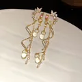 Detailed macro view of elegant gold butterfly flower tassel earrings on ceramic - Gold