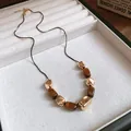 Close-up of vintage tiger eye stone necklace with gold irregular metal beads on a jewelry tray - Rectangular Tiger Eye Irregular Decoration (42#) / Gold Brown