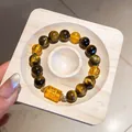 Detaillierte Nahaufnahme eines Tigeraugen-Perlenarmbands mit gelben Perlen auf Holz - 69# Armband (Mit exquisiter Geschenkbox) / Gold