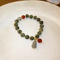 Close-up of New Chinese style jade-like beaded bracelet with a grey hulu gourd charm - Green