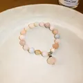Detailed macro view of a New Chinese style jade beaded bracelet with a flower pendant - Colorful