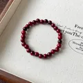 Detaillierte Makroansicht eines dunkelroten Holzperlenarmbands auf einem Canvas-Tablett - Vintage Rote Perlen Stil (75) / 6mm (Exquisite Geschenkbox) / Rot