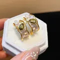 Dettaglio di orecchini stile francese con zircone verde e perle su scatola di velluto bianco - Stile Onda Zirconia Goccia d'Acqua (HE30503) / Oro