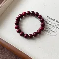 Makroansicht eines dunkelroten Perlenarmbands auf einem eleganten Schmucktablett - Rote Perlen im Antiken Stil (77) / 10mm (Exquisite Geschenkbox) / Rot