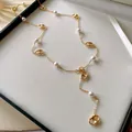 Close-up of gold-plated pig nose links and pearls on a French style long necklace - Pig Nose Pearl Long Sweater Chain / Gold