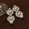 Macro detail of vintage floral earrings featuring sparkling crystals and pearls on brown fabric. - Necklace and Earrings Set (with Silver Earring Post) / Silver