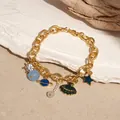 Elegant ocean-themed gold charm bracelet with sea shell, star, and planet pendants - Planet Charm Bracelet (HB2985) / Gold Blue