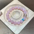 Elegantes Armband aus rosa Rosenquarzkristallperlen mit türkisfarbenem Spacer auf Holztablett. - 109# Armband-Stil / Rosa