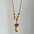 Detailed macro view of vintage mushroom pendant necklace with wooden beads and cord - Mushroom Pendant / Brown
