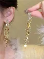Close-up detail of sparkling gold tassel earrings featuring zircon crystals and sequins - 47# Silver Needle - Gold
