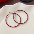 Detailed close-up view of elegant Ankara red large hoop earrings on a white plate - Circular Plain Ring / Diameter 50mm / Ancorra Red