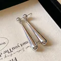 Elegant polished silver waterdrop earrings with a smooth metallic finish in close-up - Silver