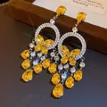 Dettaglio di orecchini a farfalla vintage con zirconi gialli e gocce scintillanti - Stile Nappine Farfalla Gialla (15#)