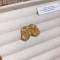 Dettaglio macro di orecchini ovali in oro vintage con eleganti motivi a diamante - Stile Ovale Fiore Svuotato (17#)