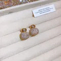 Primo piano di orecchini vintage a fiore con strass scintillanti in un vassoio portagioie. - Stile Bocciolo Pieno di Diamanti (19#)