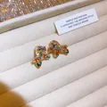 Vista macro di orecchini a perno a farfalla con zirconi colorati su velluto beige - Stile Orecchino Fiocco Multicolore (31#)