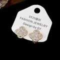 Detailed view of 18k gold plated flower ear clips with sparkling cubic zirconia stones - Clip-On Earrings / Gold