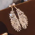 Dettaglio di orecchini pendenti a foglia d'oro vintage con cristalli baguette brillanti - Stile Nappine Foglia Stratificata (38#)