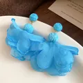 Dettaglio di orecchini a fiore in chiffon blu con perline di rafia e dettagli dorati - Orecchini pendenti / Blu