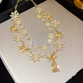 Elegant vintage gold necklace featuring butterfly motifs and crystals with pear drop - Necklace / Gold