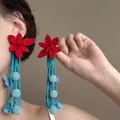 Detailed view of red flower earrings with long blue beaded tassels on model - 30# Silver Needle - Red Blue