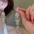 Detailed macro view of luxury pink crystal flower tassel earrings worn by a model - 37# Silver Needle - Pink