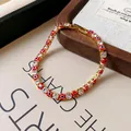 Detailed macro view of the red evil eye beads and clear cubic zirconia bracelet design. - Red
