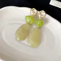 Detail of vintage-style drop earrings featuring green and yellow marbled resin pendants. - Color-clashing Teardrop (HE28092) / Silver Needle / Green