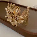 Detail shot of elegant gold flower metal cuff bracelet with textured open design. - Gold Stereo Layered Flower Style (HB2488)