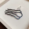 Macro detail of a minimalist matte black wave-shaped U-hair fork on a prop card. - Four-Tooth Wave Hair Stick (HH8838) / Matte Black