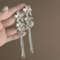 Close-up view of elegant silver floral tassel earrings featuring intricate petal details. - 8# Five-Petal Flower Tassel Style / Silver