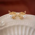 Close-up detail of gold butterfly stud earrings with white pearls and zirconia stones - 29# Butterfly Wreath Pearl Style / Gold