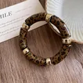 Macro view of vintage leopard print acrylic bracelet featuring polished gold spacers - Light Coffee