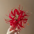 Detailed view of handcrafted red fabric spider lily flower hair clip held against neutral background - Duckbill Clip (16#) / Red
