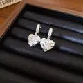 Macro di orecchini a cuore in argento con fiocco e pietre scintillanti in una scatola - Collana a cuore con fiocco / Argento