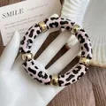 Macro detail of retro acrylic leopard print round bracelet with gold accent spacers - Pink-Black