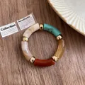 Detail of retro acrylic bracelet with multi-colored marble segments and gold spacers. - Colorful