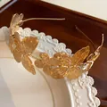 Primo piano di cerchietto a farfalla in metallo dorato con ali testurizzate - Cerchietto (HH5908) / Oro