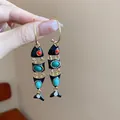 Handheld display of elegant black enamel fish dangle earrings with turquoise and coral accents - Flexible Fish Enamel Style (127#) / Gold-Black