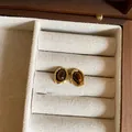Close-up view of vintage gold stud earrings with tiger eye stone in a fabric lined box - Oval Style (66)