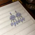 Runde silberne Quastenohrringe mit funkelnden Kristallen in einer Geschenkbox-Ansicht. - Silber