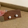 Detail of round white pearl stud earrings on a dark wooden display block - Imitation Shell Pearl (HE8071) / 10mm/Pack