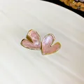 Close-up view of elegant pink heart-shaped earrings with gold trim and enamel finish - Pink