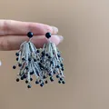 Elegant silver-toned tassel earrings with glossy black beads held for scale display - Silver Earring Post-Tassel Stud Earrings (148#) / Silver-Black