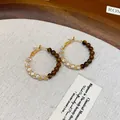 Close-up of gold-plated hoop earrings featuring tiger eye beads and crystals - Tiger Eye Beaded Hoop (WE5120----1) / Gold + Coffee